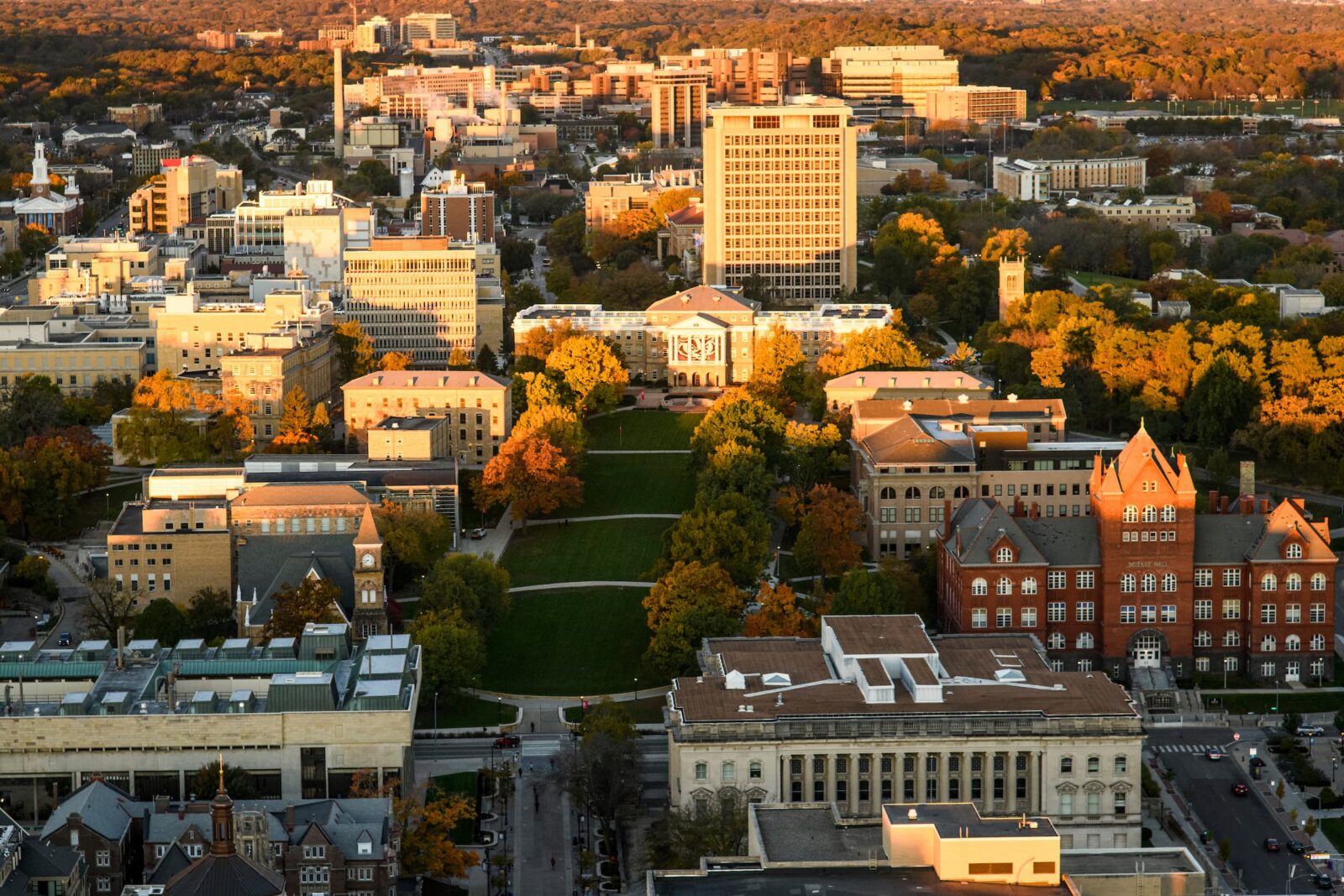 Aerial view of UW–Madison lined with fall trees leading to Bascom Hall at the center, with surrounding campus buildings in the background.
