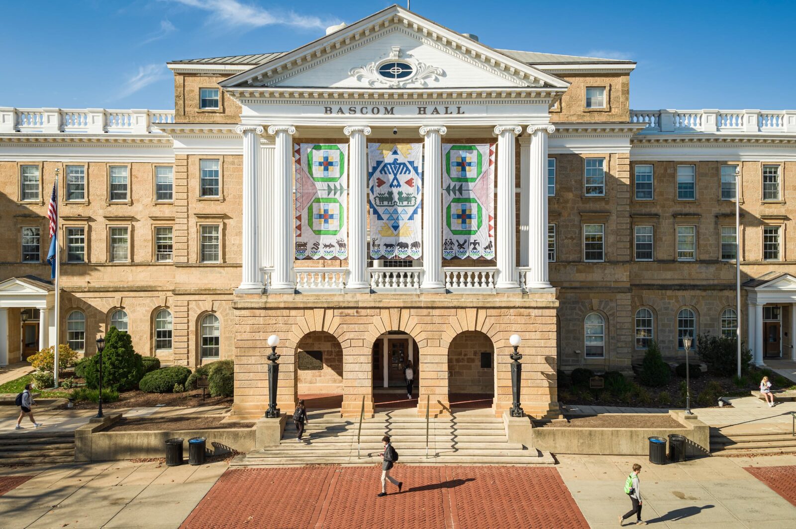 Bascom Hall with colorful banners featuring Ho-Chunk patterns displayed between the columns.